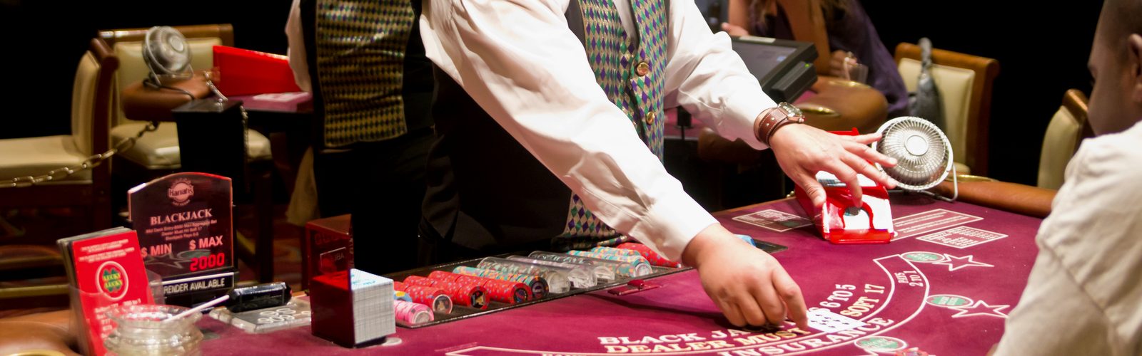 Blackjack table with chips, cards and a dealer
